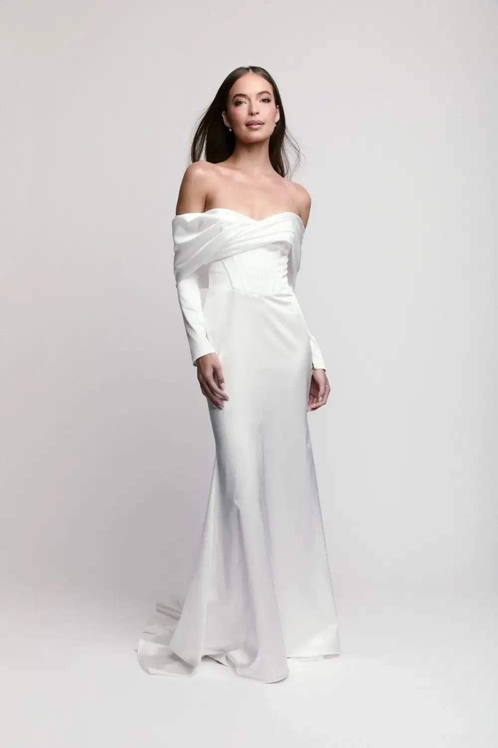 model is wearing an off the shoulder long sleeve wedding dress