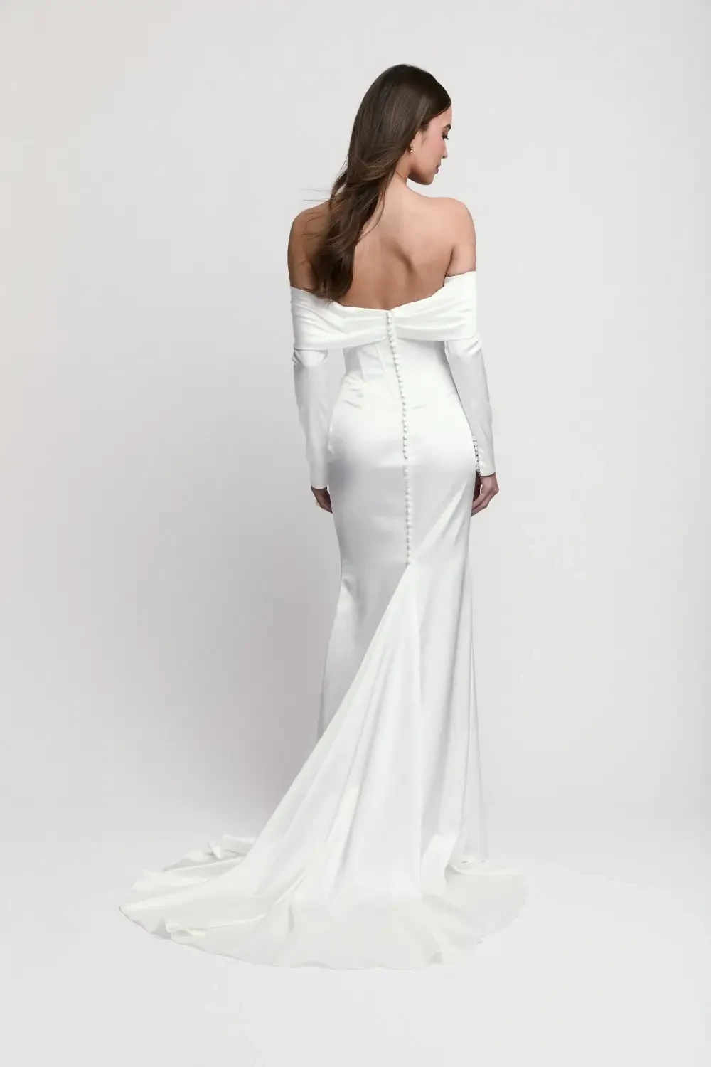 model is wearing an off the shoulder long sleeve wedding dress