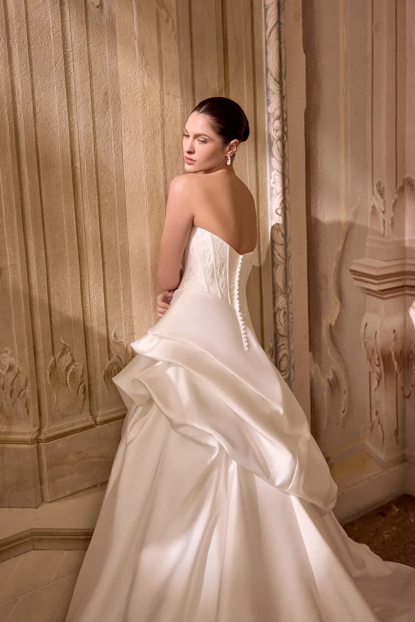 model is wearing a strapless ball gown by justin alexander