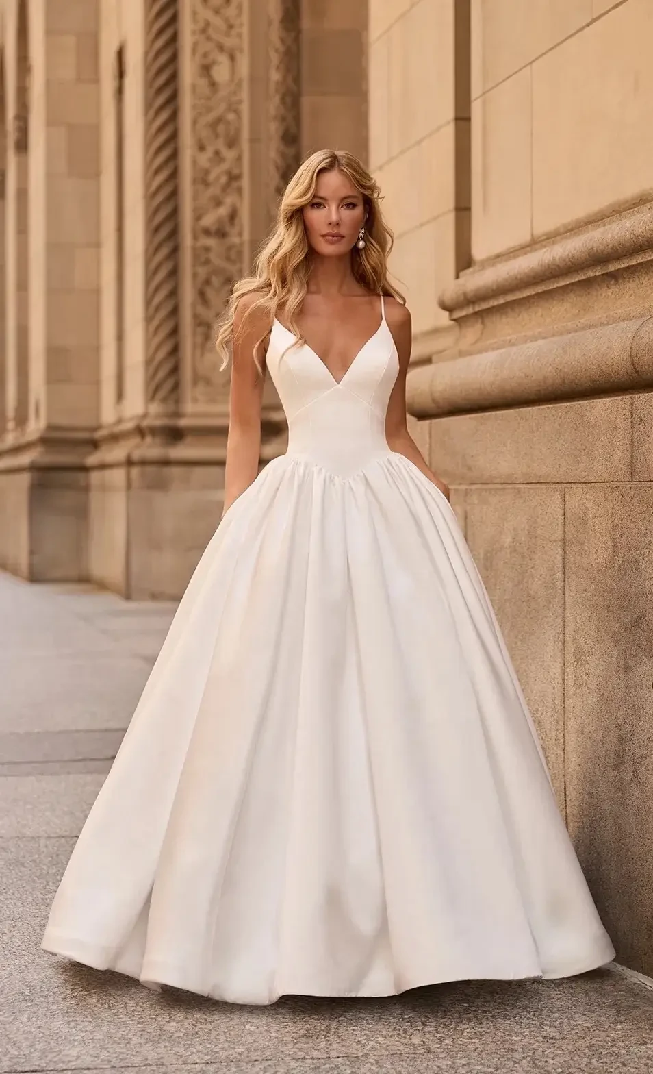 model is wearing a sleeveless high neck wedding gown
