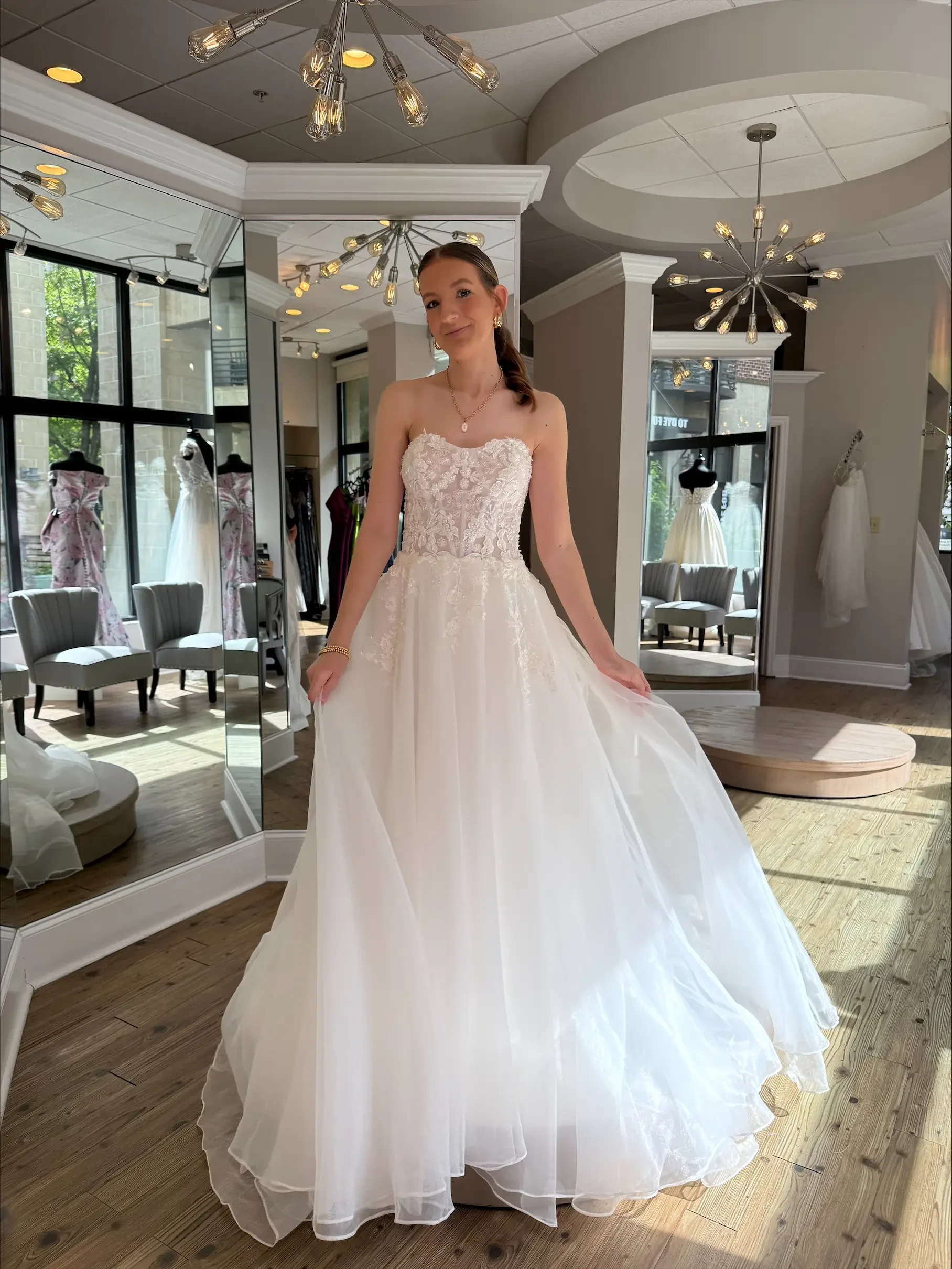 Model is wearing a strapless a-line wedding dress with a lace bodice